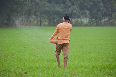 Rear view of man standing on field