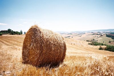 Hay bales on field against sky