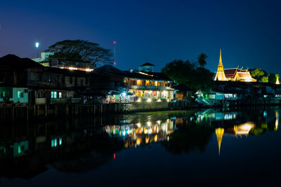 Reflection of buildings in lake at night