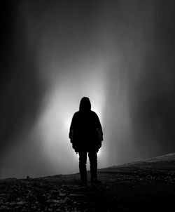 Rear view of silhouette man standing on land