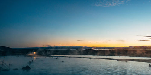 Scenic view of natural spa in iceland against sky at sunset