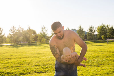 Young man standing on field against sky