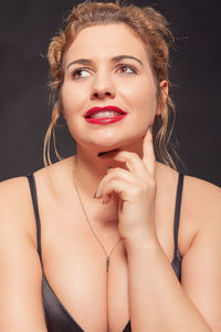 Close-up of smiling young woman against gray background