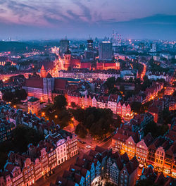 High angle view of illuminated cityscape against sky at dusk