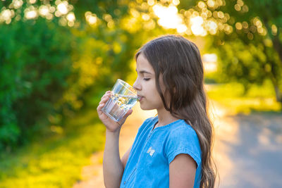 Girl drinking water at park