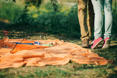 Low section of couple standing on grass