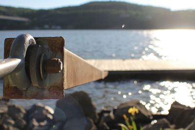 Close-up of metal rod attached to pier on lake during summer