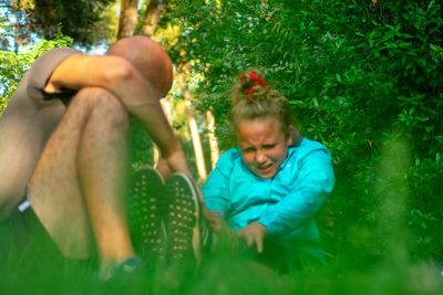 Rear view of girl and plants against trees