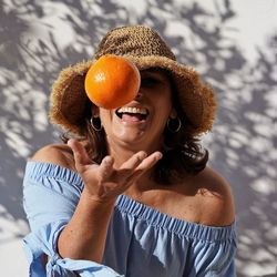 Portrait of woman holding orange 