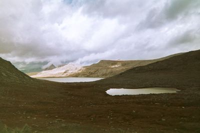 Scenic view of mountains against cloudy sky