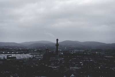 View of cityscape against cloudy sky