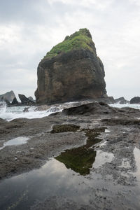 Scenic view of cliff by sea against sky