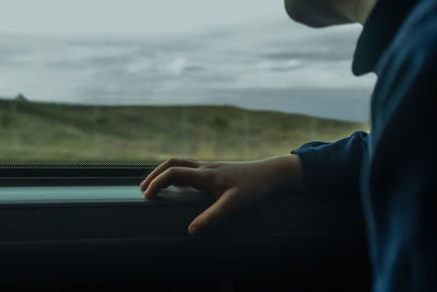 Midsection of man against sky seen through window