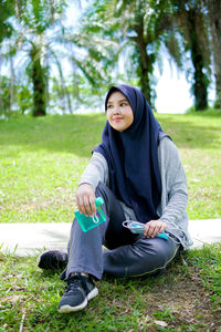 Portrait of young asian muslim sports woman relaxing outdoors after workout