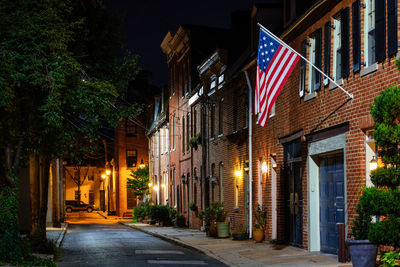 Illuminated street amidst buildings at night