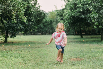 Full length of cute girl running on field