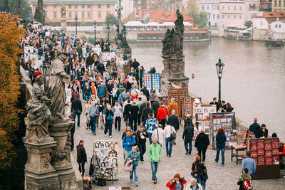 High angle view of people walking on footpath by river in city