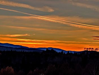 Scenic view of silhouette mountains against orange sky