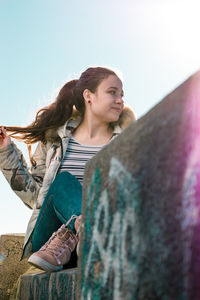 Young woman standing against clear sky