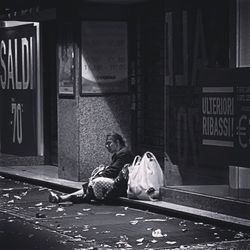 Full length of man relaxing on sidewalk