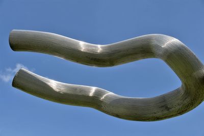 Low angle view of sculpture against clear blue sky