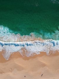 High angle view of waves rushing towards shore