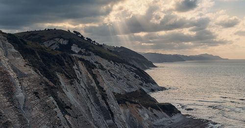 Scenic view of sea and mountains against sky