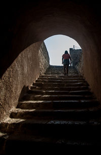 Rear view of woman standing on staircase