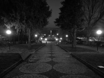 Illuminated walkway against sky at night