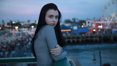 Portrait of beautiful woman in city at night