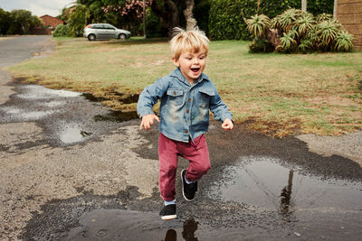 Portrait of boy running on road