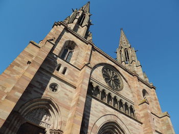 Low angle view of bell tower against blue sky