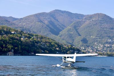 Sailboat sailing in sea against mountain