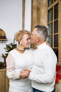 Side view of couple standing at home