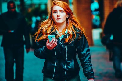 Young woman using mobile phone while standing outdoors