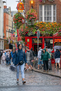 People walking on street against buildings in city