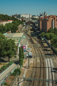 Royal palace and almudena cathedral on the horizon and a train station with rails in madrid, spain.