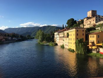 Town by river against sky