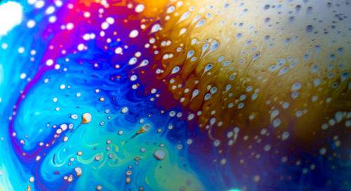 Close-up of water drops on multi colored glass