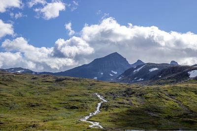 Scenic view of mountains against cloudy sky