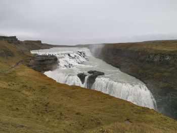 Scenic view of waterfall against sky