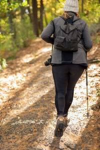 Rear view of man walking on footpath