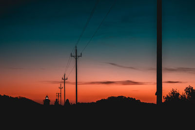 Silhouette electricity pylon against sky during sunset