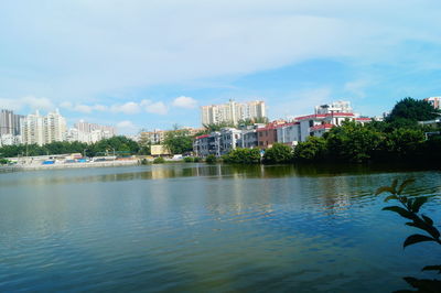 Buildings by sea against sky in city