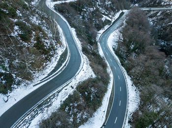 High angle view of road amidst trees during winter