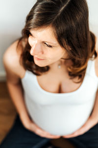 High angle view of pregnant woman sitting at home