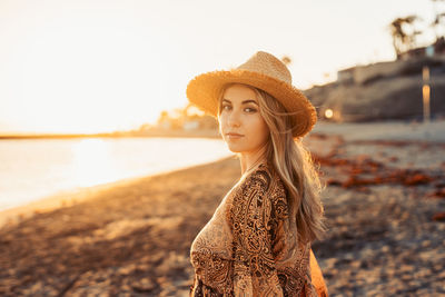 Portrait of young woman standing against sky