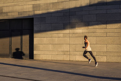 Full length of woman running on wall