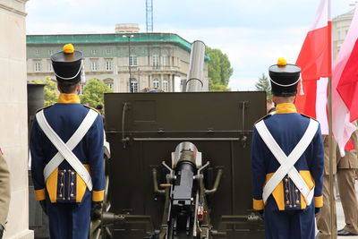 Artillerymen standing by cannon in city