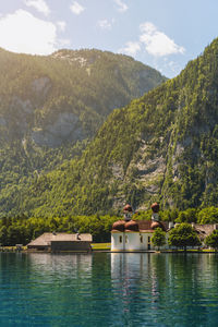 Scenic view of lake by mountains against sky